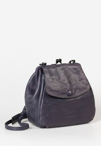 Borsa a tracolla in pelle viola scuro con forma arrotondata, chiusura a patta e texture liscia. Caratterizzata da una tracolla removibile e accenti di design minimalista.