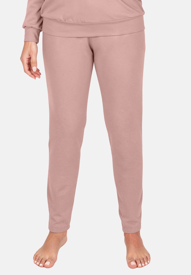 Pantalones de descanso ajustados de color rosa claro, con una textura suave y cintura elástica, ajustados en los tobillos, que muestran un diseño sencillo.