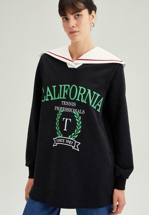 Fekete pulóver nagy zöld "CALIFORNIA" felirattal, fehér tengerészkollárral, piros akcentussal és grafikai részletekkel. Hosszú ujjú.