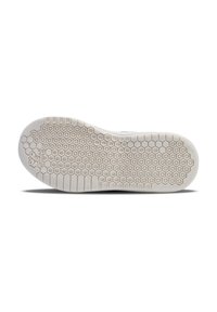 Suela de zapato con un material de goma blanca texturizada con un patrón de panal, que proporciona tracción y agarre.