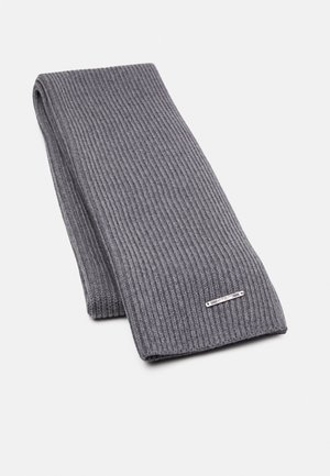 Écharpe en tricot côtelé gris foncé pliée avec une petite étiquette logo métallique rectangulaire sur fond blanc.