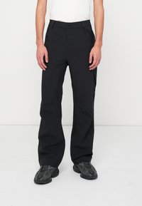 Fekete technikai nadrág egyenes szabással, oldalsó cipzáras zsebekkel és övbújtatókkal. Sima, tartós anyag, letisztult dizájnnal.