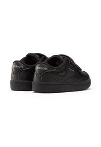 Sorte Reebok joggesko med lavt skaft, som har borrelåsremmer, teksturert gummisåle og sydd detaljer for holdbarhet.