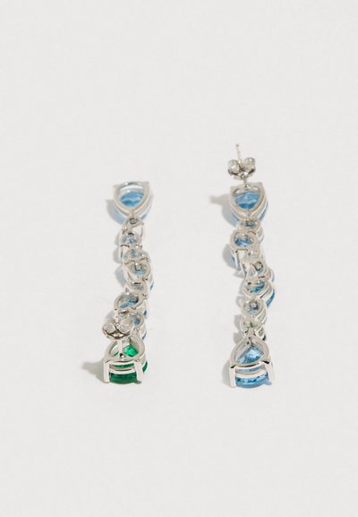 Brincos em tom prateado com pedras preciosas azuis e verdes, em design entrelaçado com formas de gota e detalhes brilhantes.