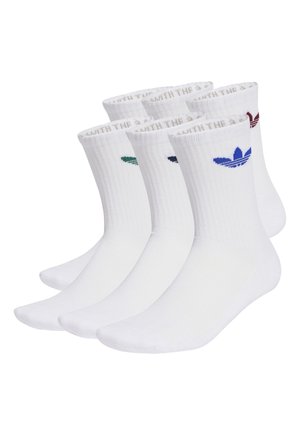 Pięć par białych skarpet za kostkę z prążkowanymi ściągaczami, każda z innym kolorowym logo Adidas trefoil blisko góry.