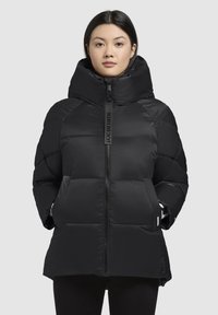 Black puffer jacket with a high collar, zip closure, and side pockets. Features quilted design and textured fabric.