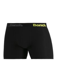 Black boxer shorts with a snug fit, featuring a contrasting yellow and gray elastic waistband with "Bench." logo prominently displayed.