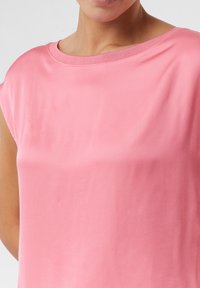 R roze hemd met korte mouwen en een gladde textuur, en een wijde halslijn. Eenvoudig ontwerp, lichte stof, ideaal voor casual gebruik.