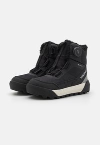 Bottes noires imperméables avec un dessus en tissu texturé, système de fermeture BOA et semelle extérieure renforcée pour une bonne traction. Comprend une doublure douce et un détail de logo.