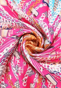 Foulard in seta con uno sfondo rosa vivace, disegni intricati di catene e pattern, dalla texture morbida e colori ricchi che includono tocchi di oro e blu.