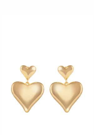 Kolczyki w kolorze złota z dwoma połączonymi kształtami serca, mniejszym sercem u góry i większym sercem zawieszonym poniżej na każdym kolczyku.