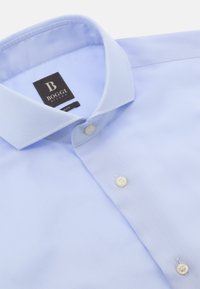 Helles blaues Hemd aus einem strukturierten Fischgrätmuster. Mit einem Kentkragen, weißen Knöpfen und einem Markenetikett.