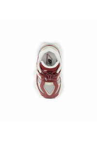Red and white athletic shoe with mesh upper, padded collar, and contrasting accents. Features stylish lacing and logo on insole.