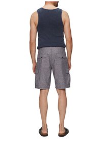 Herren Tanktop in Marineblau mit Rippstruktur, kombiniert mit hellgrauen Cargo-Shorts, die über mehrere Taschen und einen strukturierten Stoff verfügen. Getragen mit schwarzen Sandalen.