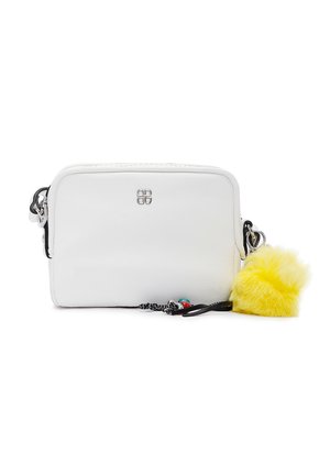 Bolso bandolera rectangular de cuero blanco con logotipo plateado, correa en blanco y negro, y un llavero amarillo peludo adjunto.