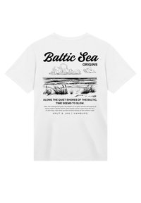 White T-shirt displaying black illustration of the Baltic Sea with clouds and grass, text "Baltic Sea" and "ORIGINS" above, and description below.