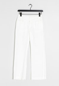 Valkoiset liinapöksyt suoran lahkeen muotoilulla, joissa on etupocketit ja kaksoispainonappi kiinnitys, roikkuvat mustalla henkarilla.