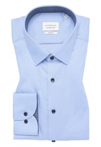 Lichtblauw slim-fit overhemd met donkere knopen, gemusterde kraagvoering en een net gevouwen manchet met accentdetail. ETERNA merklabel.