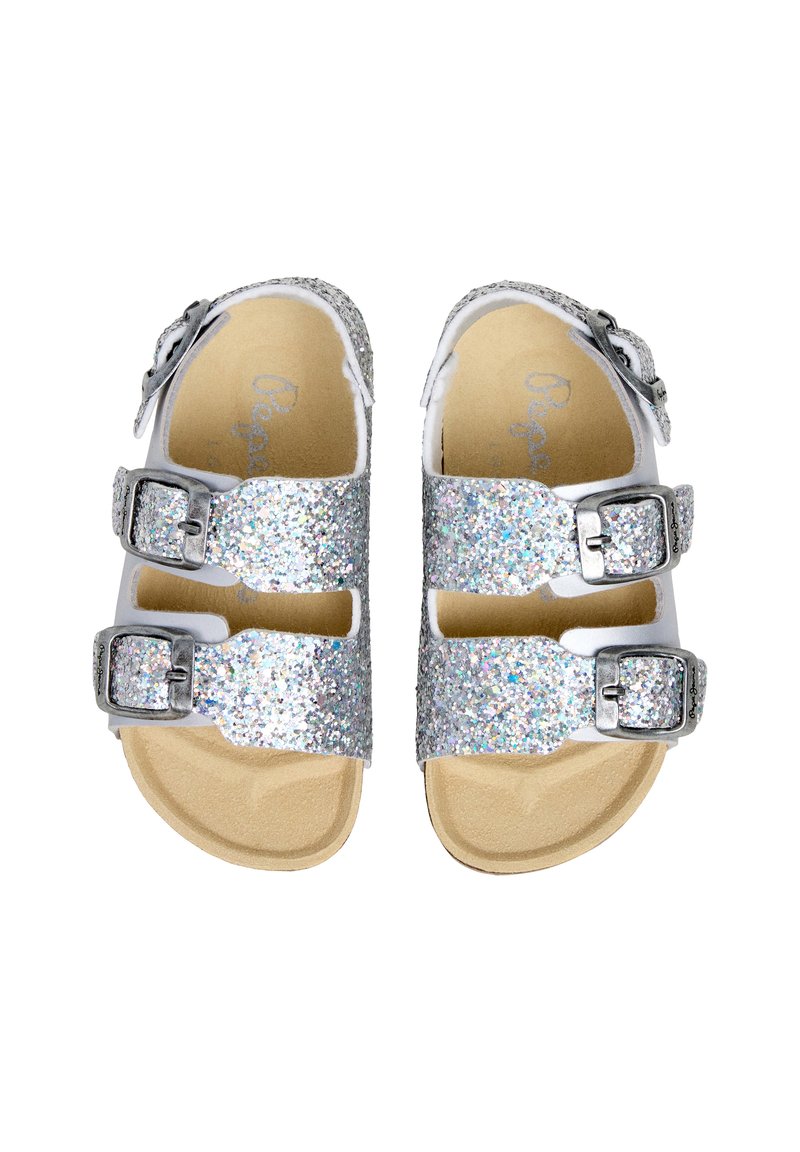 Sandalias de doble tira con purpurina plateada, hebillas metálicas ajustables y plantillas acolchadas color canela, vistas desde arriba sobre un fondo blanco.