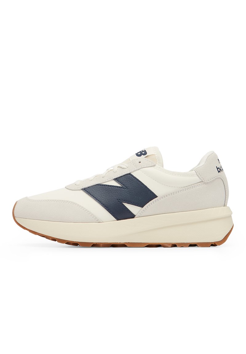 Men's sneakers in cream and navy, featuring a suede and mesh upper, rubber sole, and a prominent navy "N" logo on the side.
