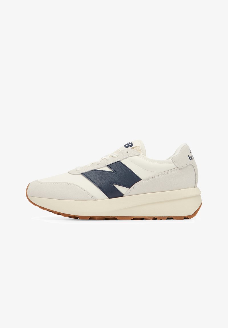 Men's sneakers in cream and navy, featuring a suede and mesh upper, rubber sole, and a prominent navy "N" logo on the side.