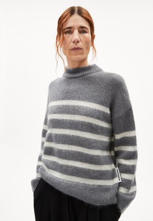 Grey and white striped sweater with a high neckline, made of soft material. Features a loose fit and a side tag detail.