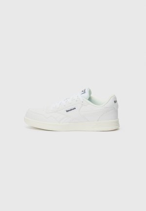 White athletic shoe made of smooth leather with a rounded toe, lace-up closure, and subtle branding on the side and heel.
