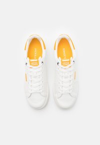 Weiße Sneakers mit strukturierter Oberfläche, ausgestattet mit orangen Einlegesohlen und Branding. Abgerundete Zehenpartie, Schnürdesign und minimalistischer Stil.