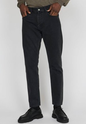 Zwarte denim jeans met een rechte pasvorm, voorzien van vijf zakken, riemlussen en een subtiele textuur. Draag ze met zwarte veterschoenen.
