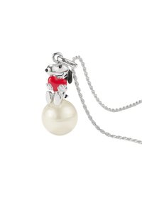 Silberne Halskette mit einer Hundefigurine, die ein rotes Herz hält und auf einer großen, glatten, weißen Perle sitzt. Tag mit der Aufschrift "Peanuts".