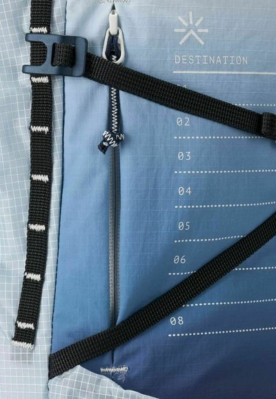 Zaino con gradiente blu caratterizzato da un motivo a griglia, spallacci neri in tessuto, tasca con zip e segni di misurazione stampati sulla superficie.