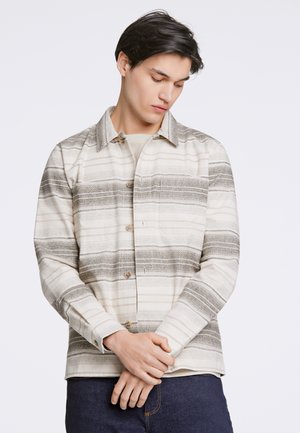 Chemise rayée beige et grise avec un devant à boutons, un col pointu et des manches longues. Tissu doux avec une texture subtile.