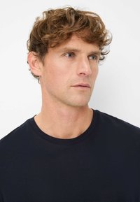 Zwart crew-neck t-shirt gemaakt van zachte stof; heeft korte mouwen en een gladde textuur zonder zichtbare patronen of versieringen.