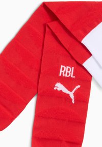 Calcetines deportivos rojos con el logo blanco de Puma y el texto "RBL", con patrones de chevron texturizados y puños de canalé blancos.