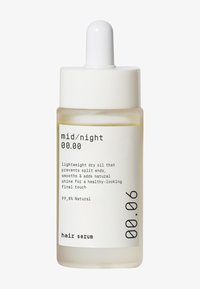 Følende lett hårserum i en klar glassflaske med en hvit dråpeteller. Etiketten har svart tekst på hvit bakgrunn, som beskriver fordeler og naturlig innhold.