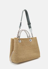 Vävd halmhandväska i tan med silverfärgade detaljer, dubbla handtag och avtagbar grön rem. Har en strömlinjeformad form och vita accenter.