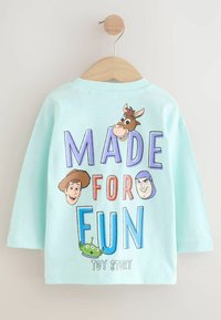 Himmelblaues Langarmhemd mit Grafik, die Figuren aus Toy Story zeigt. Der Text lautet "MADE FOR FUN" in bunten Buchstaben.