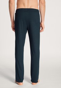 Marineblauwe, lichte pyjamabroek met een elastische tailleband. Rechte pijpen, zachte textuur en geen zichtbare patronen of accenten.