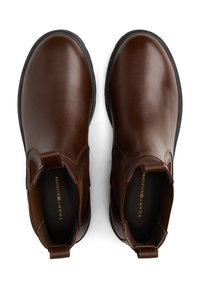 Braune Lederknöchelstiefel mit elastischen seitlichen Einsätzen, Zuglaschen und einer schwarzen Gummisohle. Glatte Textur mit leicht glänzender Oberfläche.