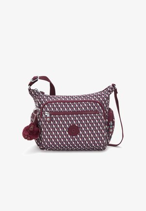 Sac à bandoulière en tissu bordeaux à motifs avec une finition texturée. Comprend plusieurs poches zippées et un charm pompon sur le côté.