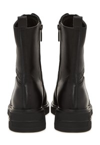 Botas de tobillo de cuero negro con una textura suave, con cremalleras en los laterales y una suela de goma apilada. Diseño minimalista con un sutil detalle de marca.