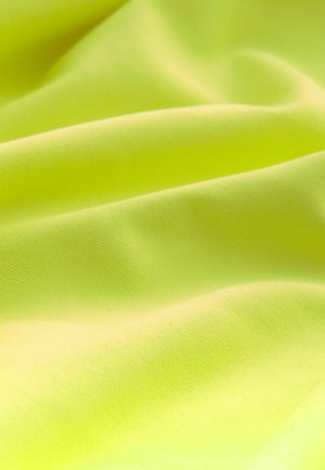 Fluorescentno žuta tkanina s glatkom, blago sjajnom teksturom, s blagim naborima i konzistentnim, finim pletenim uzorkom.