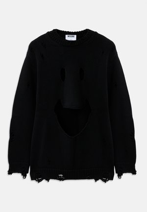 Pull en tricot noir avec des trous usés formant un visage souriant sur le devant et de petites déchirures éparpillées à travers le tissu.