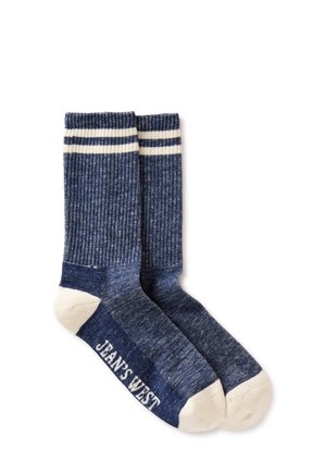 Paar marineblauwe geribbelde sokken met witte tenen, hielen, twee witte strepen bij de boorden en "JEANS WEST" bedrukt op de zool.