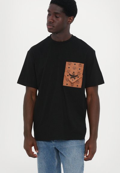 T-shirt noir à manches courtes avec une poche à motifs marron et des détails de logo. Fabriqué en tissu doux, coupe décontractée avec un col rond.