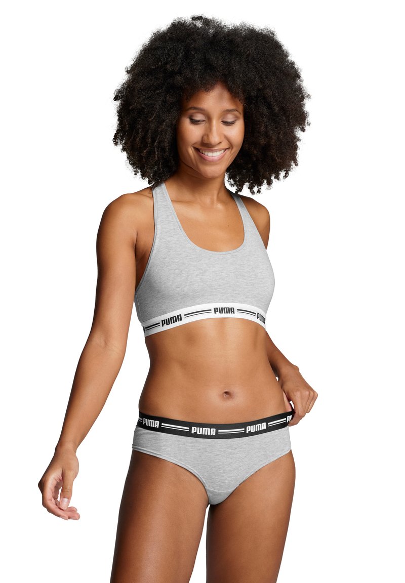 Grijze sportbh met een brede zwart-witte Puma-logo band, en bijpassende grijze slips met een zwarte band, gemaakt van zacht, rekbaar materiaal.