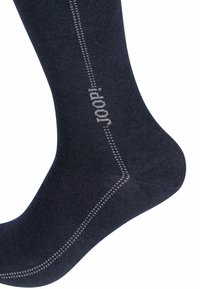 Calzino blu navale realizzato in un tessuto liscio, con un tallone e una punta rinforzati e una cucitura a contrasto di grigio chiaro lungo il lato.