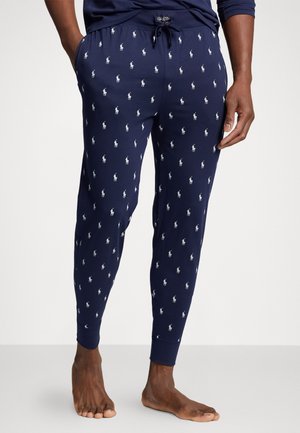 Navy cotton joggers with white Polo logos, drawstring waist, and cuffed ankles. Smooth texture, fitted design, and ankle-length.