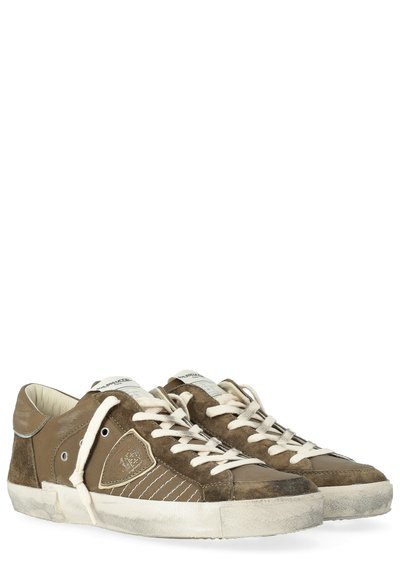 Bruine suède sneakers met witte veters, contrasterende rubberen zool en gestikte details. Opvallend logo op het zijpaneel en slijtage op de teen.