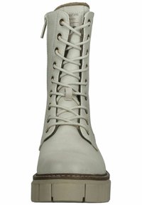 Botín blanco de cordones con cuero texturizado, ojales dorados y suela gruesa. Cuenta con una cremallera lateral para facilitar su uso.
